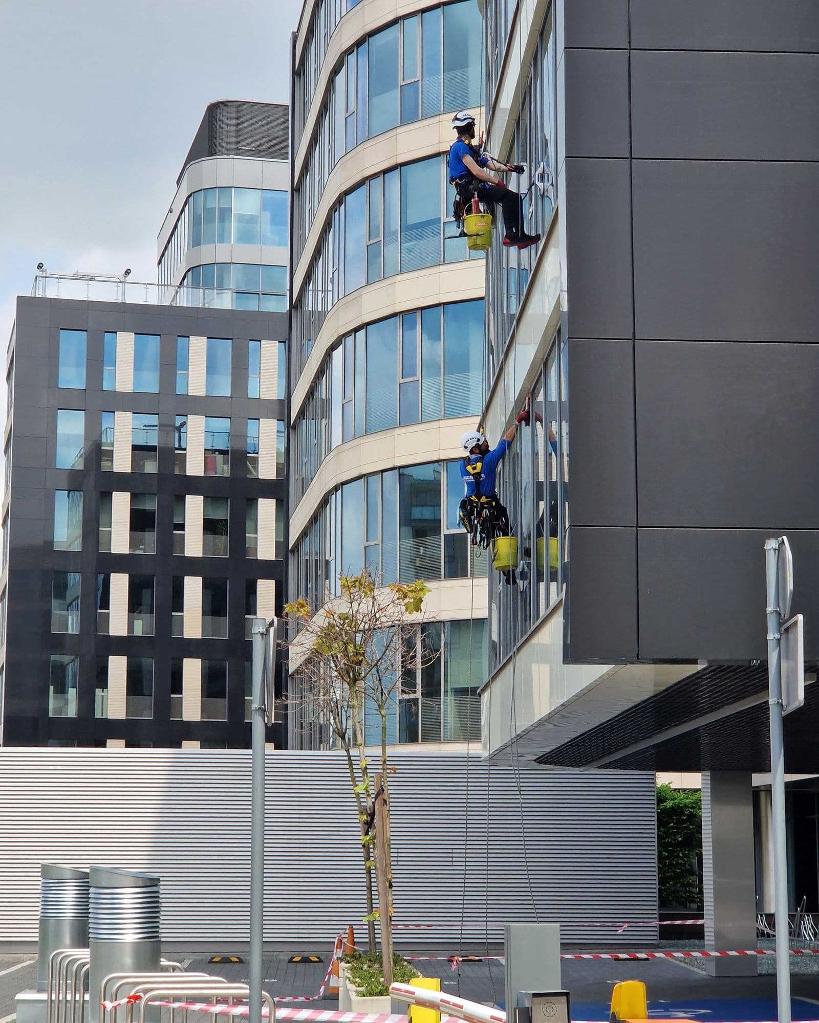 Professionals climbing and cleaning windows of an office building